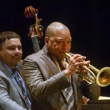 Wynton Marsalis playing trumpet with an up right bass player behind him