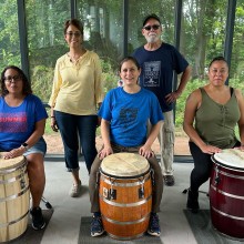 A group of people posing for a photo with drums