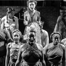 Black and white photo of actors in African inspired outfits.