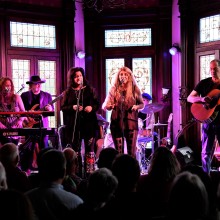 A band performing live on stage at the Lizzie Rose Music Room