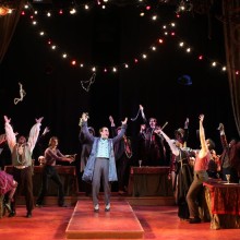 Group of actors performing on a circus-like stage.