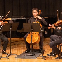 A group of young people playing string instruments
