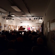 A pianist performing in front of a crowd at the Puffin Cultural Forum