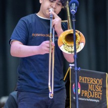 A Paterson Music Project trombonist performs in a concert.