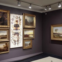 The Newark Museum of Art -  a gallery with gray walls and gilded framed paintings.