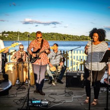 Band performing in front of a body of water