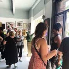 People milling inside the gallery full of artwork.