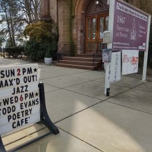 Exterior of 1867 Sanctuary Church with a sign.