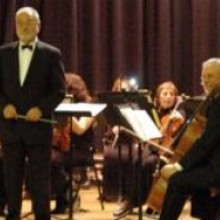 A large orchestra with a conductor in front of them