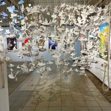 A room full of paper sculptures hanging from the ceiling.