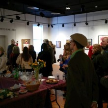 A groiup of people attending an art opening at an art gallery