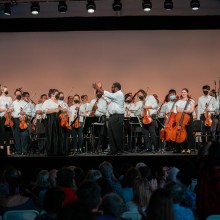 Children with string instruments stand for applause.