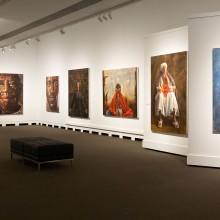 Art exhibit with paintings displayed on a white wall in the Steadman Art Gallery at Rutgers University-Camden