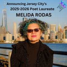 Melida Rodas, a woman in sunglasses posing in front of the Lower Manhattan skyline, in our 2025-26 Jersey City Poet Laureat