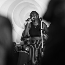 A woman is singing into a microphone on stage