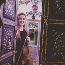 Private Music teacher opens the door to a session with a violin in hand