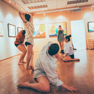 A group of dancers practicing in an art gallery
