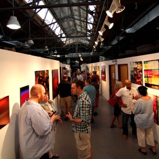 a stretch of art exhibits occupied with guests mingling about them