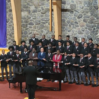 A group of men in suits singing