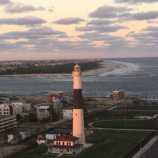 lighthouse by the water during sunset