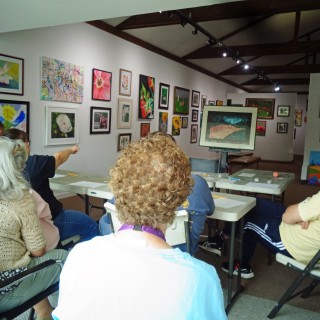 a group in an art gallery critiquing a painting