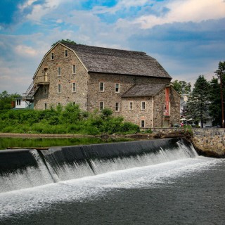 the exterior of Hunterdon Art Museum, a renovated stone Mill building in front of the Clinton Dam