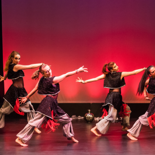 Four dancers performing on stage