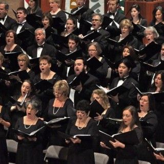 A group of people in black choir clothes singing