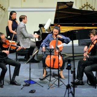 A group of four musicians playing instruments in a room