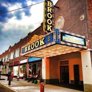 The exterior of the Brook Arts Building, with a classic theatre marquee with the theatre’s name on it
