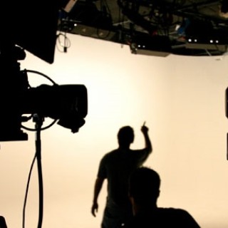Person working in front of movie cameras