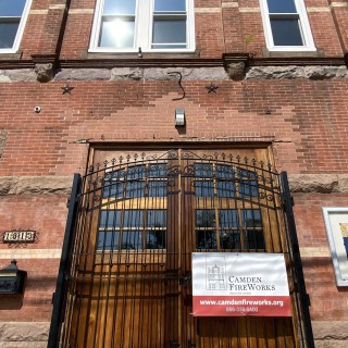 Iron gate over barn doors display a vinyl sign for Camden FireWorks