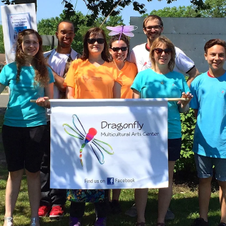 group photo of Dragonfly Multicultural Arts Center staff with sign