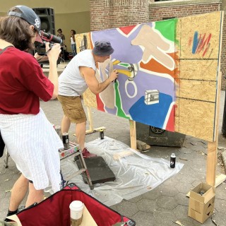 someone painting a mural while another person photographs them