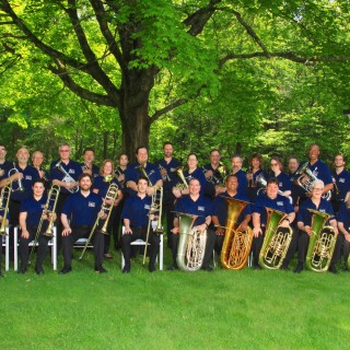 a group photo of the Imperial Brass musicians with their respective brass instruments