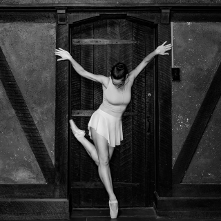 A ballerina from Allegory Dance in front of a wooden door. Photo by Impressions.Life Jeff Somers
