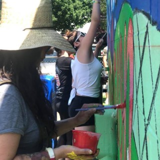 A group of women painting a mural