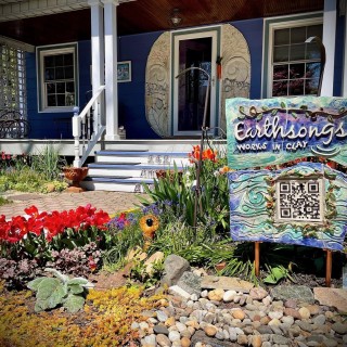 A blue house with flowers in front of it