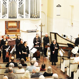 Large band playing in a white church to a seated audience