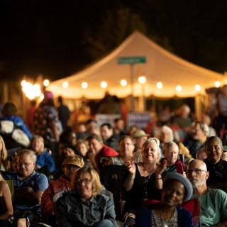 A group of people attending an outdoor nighttime event