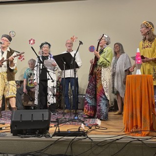 A group of folk performers onstage.