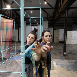 Dancers performing amongst a scaffolding set.
