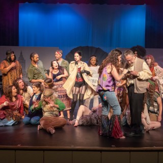 A group of actors in costume performing onstage