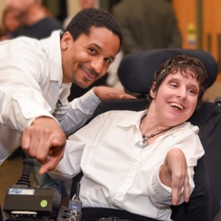 An abled bodied and a person with a disability pose for a photograph.