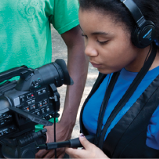 Student learning to operate a video camera.