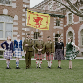Members of The Learned Kindred of Currie posing in authentic Scottish attire