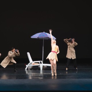 Performers on stage in a tableau of dance.