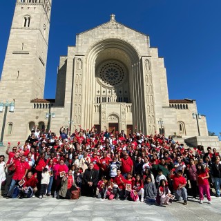 A group of people posing in front of a church.