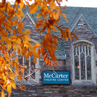 the exterior of the gothic McCarter Theatre Center for the Performing Arts with some fall foliage in front of it