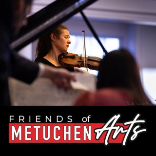 Violinist plays behind an open piano